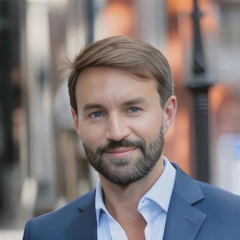 Portrait of Ulpiano Gonzalez, Country Manager for Visual Art Spain, wearing a navy blue suit and light blue shirt, smiling confidently in an urban setting