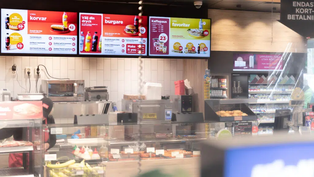Circle K digital signage and menu boards displaying food and beverage offers in convenience store